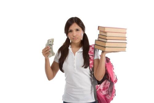 College student holding money and books, upset by tuition cost and debt
