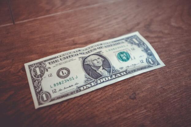 American one dollar bill laying on wood table